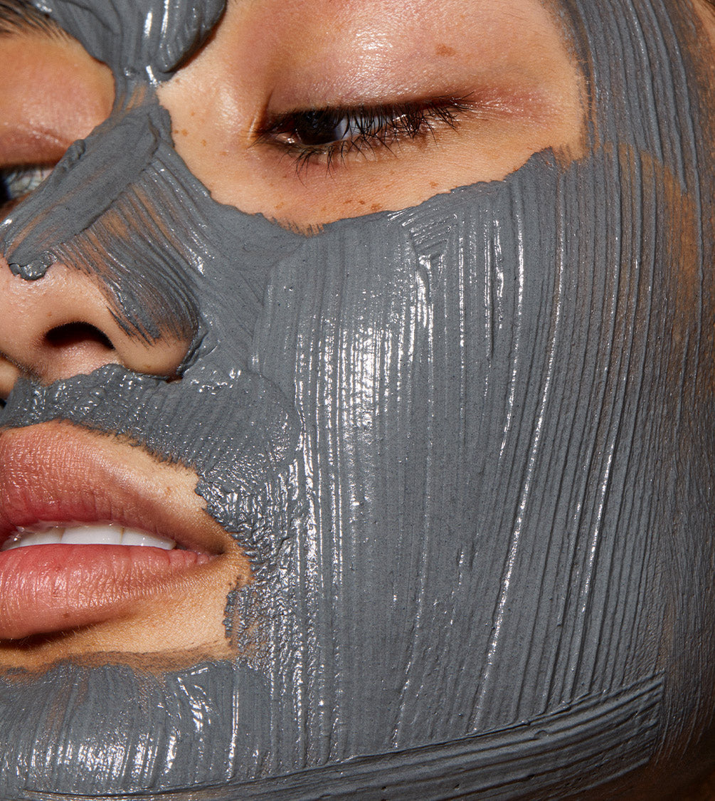 A close up of models face with Ultramoor Mud Mask applied to her face.