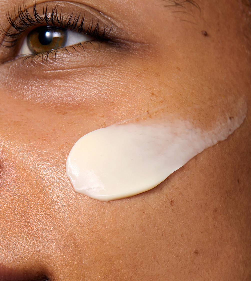 A close up of a model's face with Rejuvenating Night Cream applied to her cheek