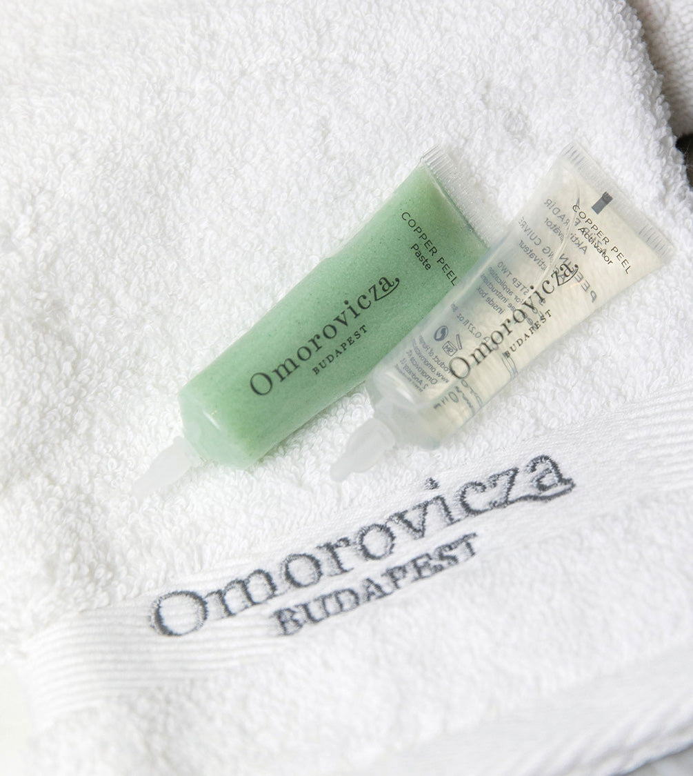 A close up of Copper peal duo placed on the towel with Omorovicza logo.