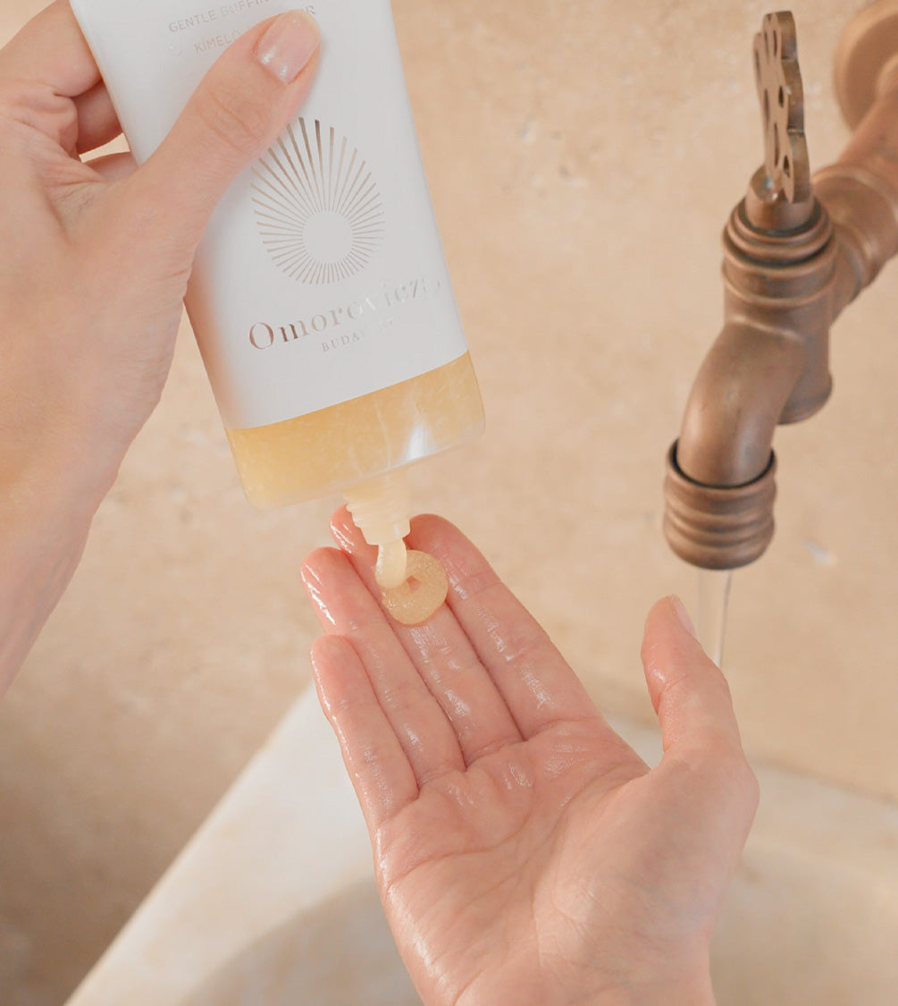 A close up of hands applying Gentle Buffing Gelée a thorough exfoliation and a gentle cleanse.
