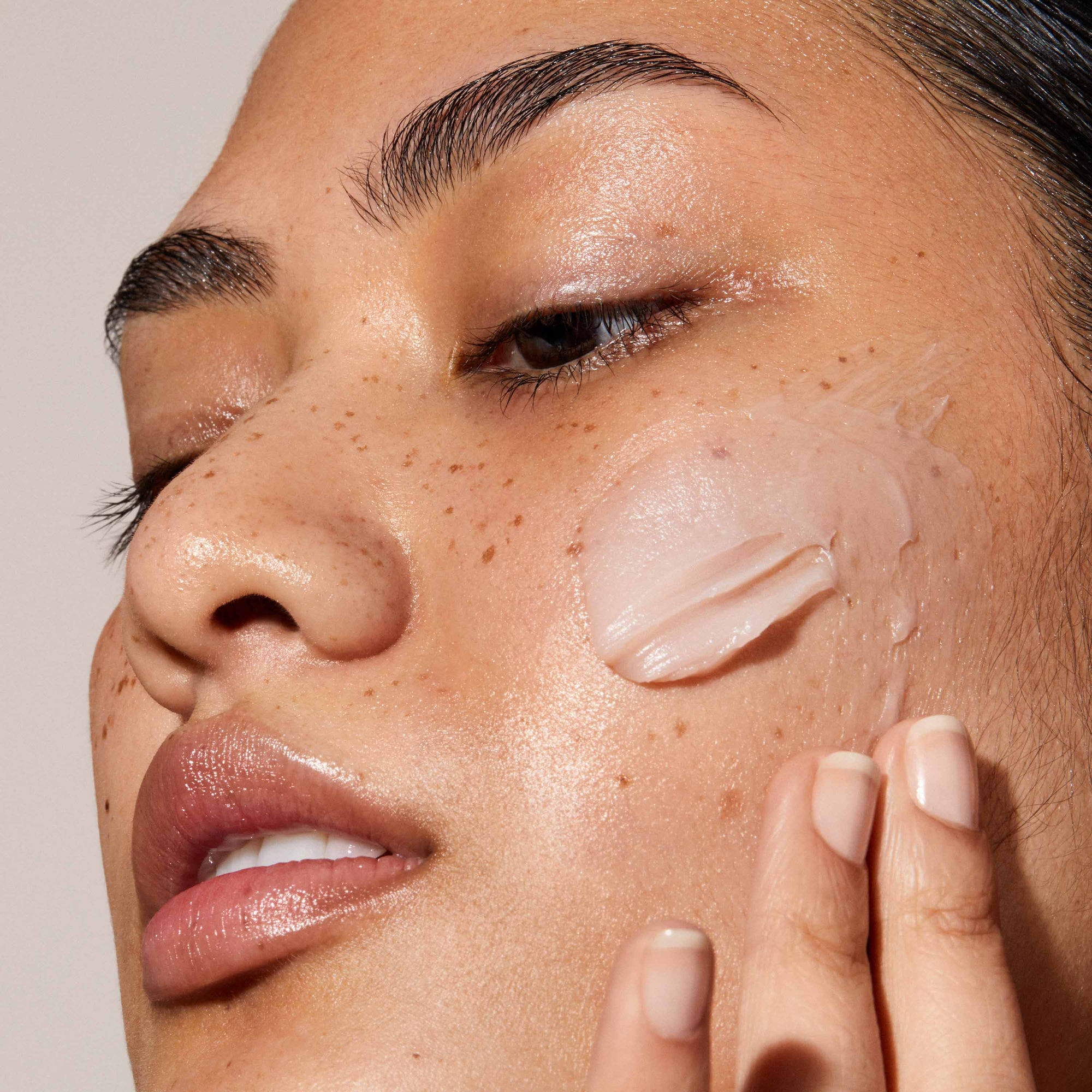 A close up of model's face with Queen Cream applied to her face. The skin looks glowy and hydrated. Nutrient-rich moisturiser combines oils to durably nourish and plump the skin